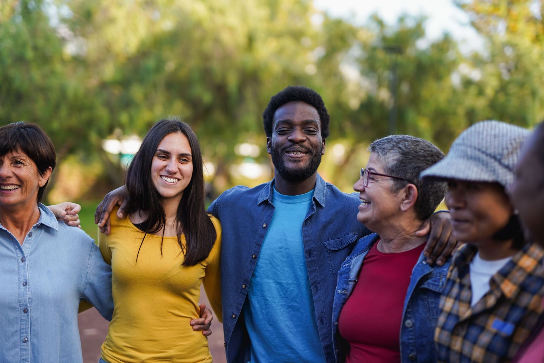 A group of people of different ages and backgrounds standing together outdoors.