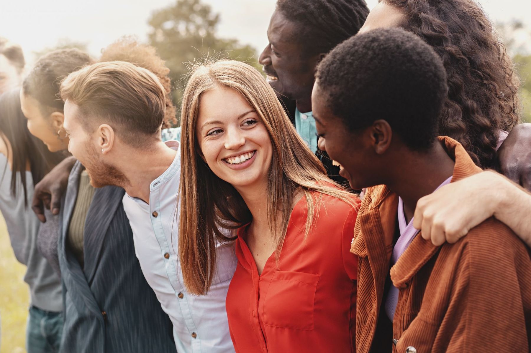 Friends standing close together and laughing outdoors.