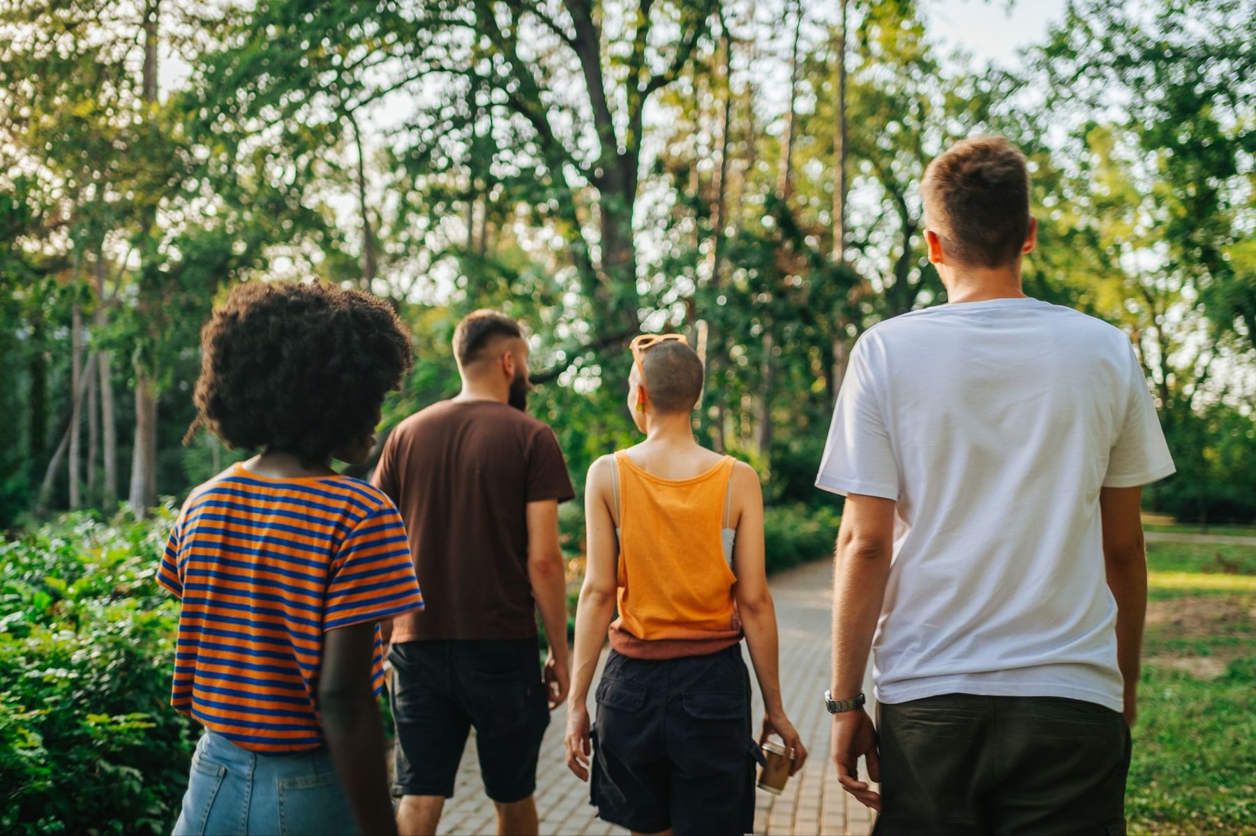 A group of people walking together along a path through a park.