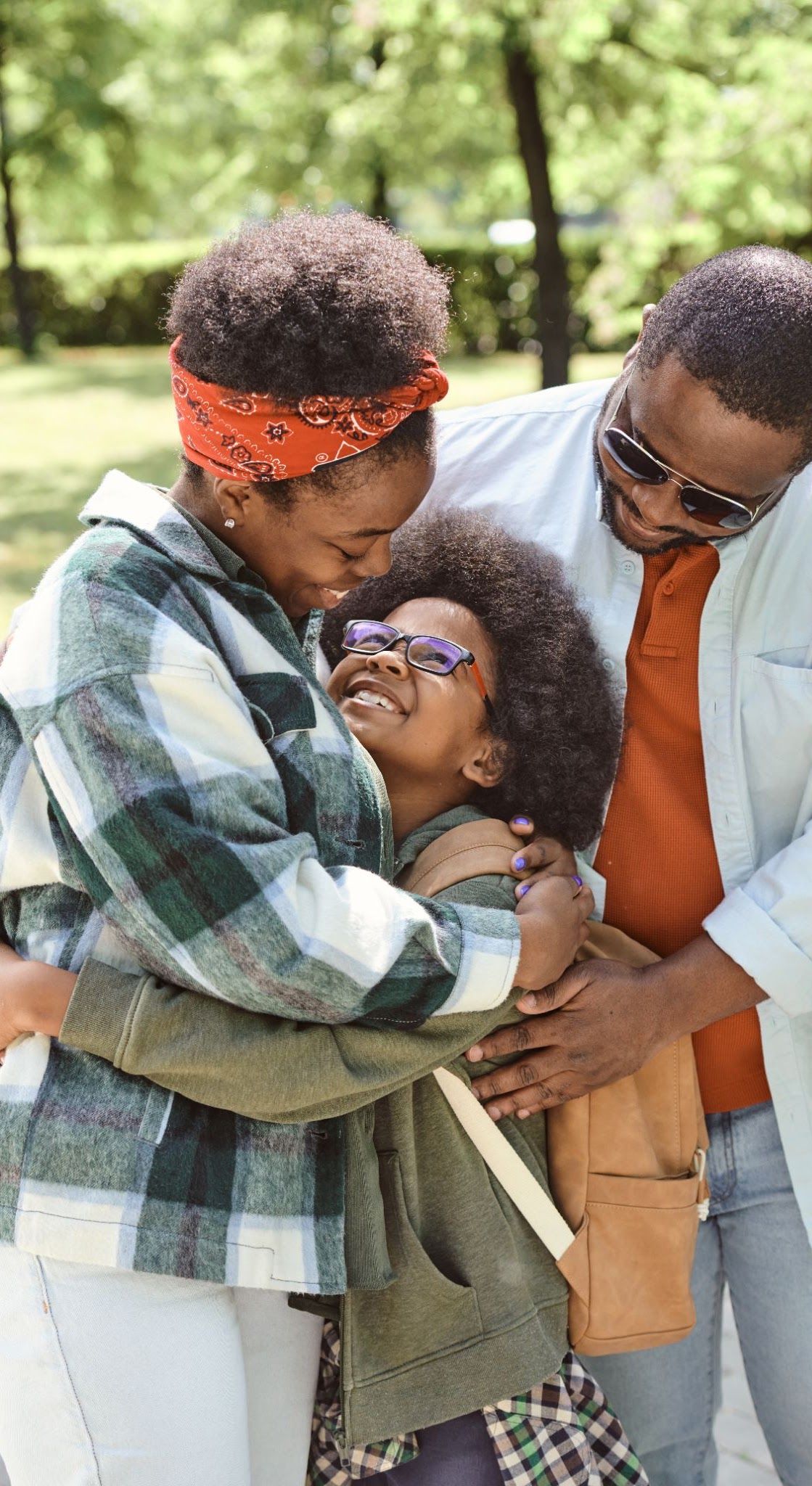 Members of a community gathered in a group embrace outdoors.